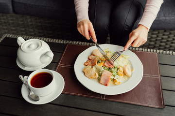 Woman hands ready to eating Caesar salad and drinking tea in the restaurant