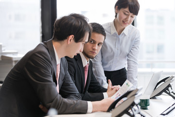 Positive workplace concept. Three young business persons having a meeting in office.