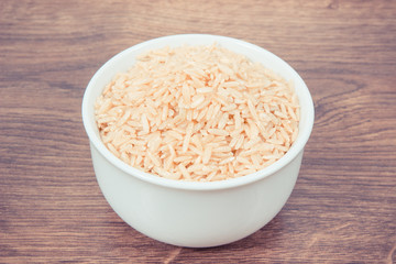 Vintage photo, Heap of brown rice in glass bowl, healthy nutrition