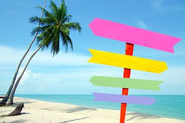 Blank color arrow road sign and tropical sea with palm tree