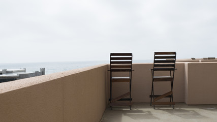 Table and two chairs on a balcony by the sea Apartment