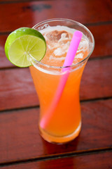 exotic fruit cocktail with slice of lime and a straw.Thailand