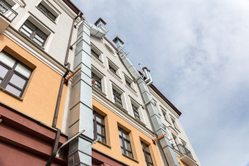 courtyard facade of urban apartment building against cloudy sky. view from bottom.