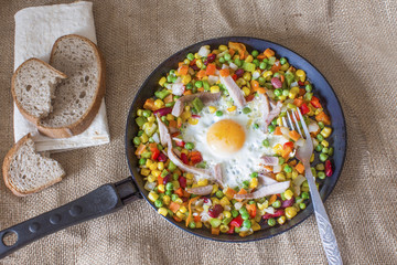 fresh hot vegetable mixture in a frying pan with fried eggs