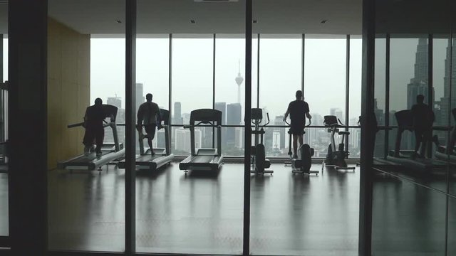 Footage of people's silhouette exercising and training in the gym in slow motion.