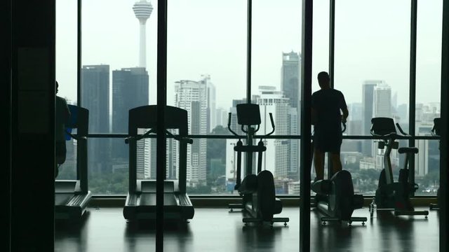 Footage of people's silhouette exercising and training in the gym in slow motion.