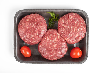 Tray with raw beef burgers or minced meat isolated on white background