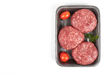 Tray with raw beef burgers isolated on white background