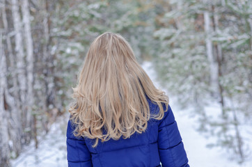 a girl with blond hair is standing with her back