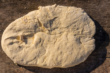 Raw fresh yeast dough for baking on rustic wooden table