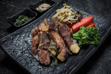 grilled meat japanese food cut on the black plate serve with vegetables