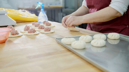 Raw meat pie on a tray made by hands