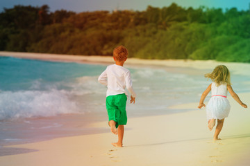 little boy and girl running on beach