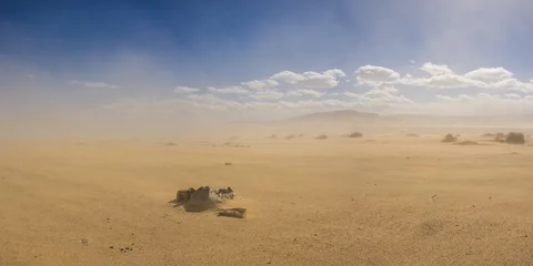 Crédence de cuisine en verre imprimé Sécheresse L& 39 anneau de pierre forme un foyer dans un vaste désert de sable sous le nuage d& 39 une tempête de sable grandissante.