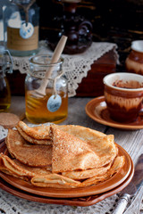 Homemade Russian openwork pancakes for carnival in honey, selective focus