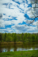 Vakulenchuk, Zhytomyr region, Ukraine. Beautiful lake with reflection of the sky in the forest. Beautiful landscape. Lake in the green forest. Beautiful clouds in the blue sky. Spring.