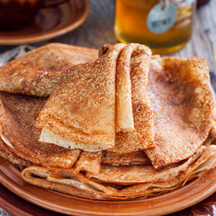 Homemade Russian pancakes on earthenware, selective focus, square