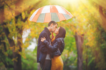 Young couple in love kissing under umbrella