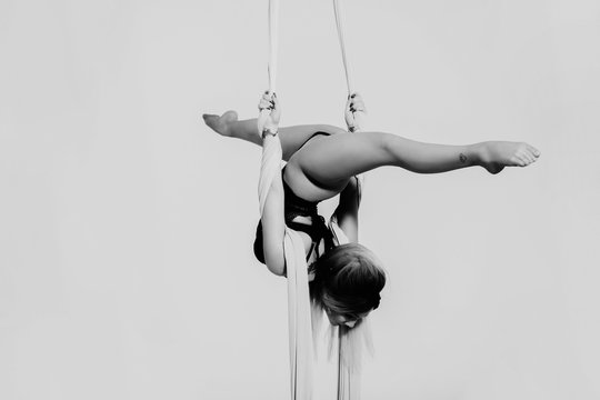 Close up image of sporty acrobatics. Hanging on silk tissue.