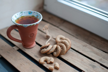 A cup of tea and homemade cookies on the wood