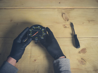 Gloved hands holding speedometer