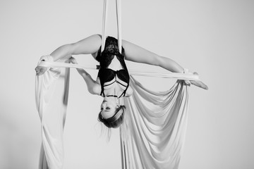 Nice aerialist hanging head foremost on silk tissues.