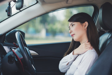 Fototapeta na wymiar Asian businesswoman having pain on her shoulder and neck while driving