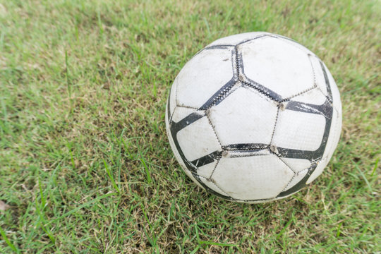 Old soccer ball on the grass of football field , Football on grasses with copy space
