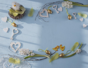 on a blue background the Easter composition: eggs, hyacinths, feathers, chicken hearts and birch branches