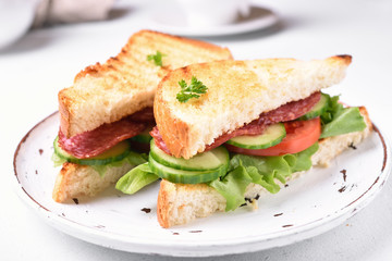 Sandwiches with salami, tomatoes, cucumber and lettuce