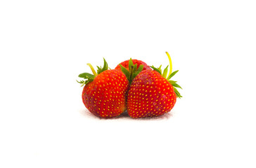 Three Red strawberries on tissue paper on white background
