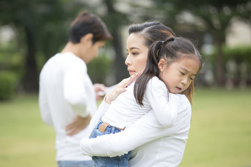 Portrait of young girl cry. mother holding her daughter in hand and father ignor.