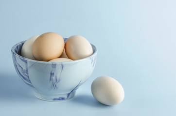 Easter bowl with eggs on blue background