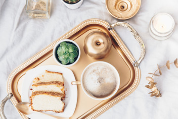 Flat lay Luxury Breakfast with coffee and gold tray. Morning coffee in bed composition. Toned Trendy Still Life