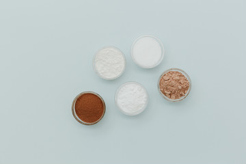 Ingredients for cooking chocolate mug cakes. Flour, cocoa powder, sugar, over pastel background. Top view, copy space, flat lay .