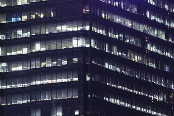Fototapeta na wymiar Highrise urban living and apartment windows at night for privacy and residential and commercial zoning concept. Warm window lights for living and property management.
