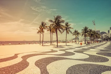 Foto auf Acrylglas Copacabana, Rio de Janeiro, Brasilien Sunny day with palms by Copacabana Beach mosaic boardwalk, Rio de Janeiro. Vintage colors with light leak