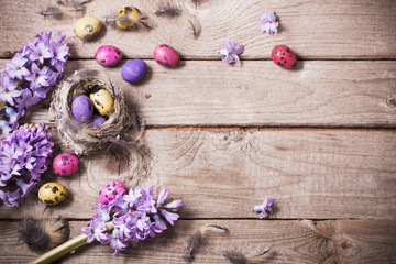 Easter eggs with spring flowers on wooden background