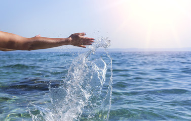 Women's hands do the spray of the sea.