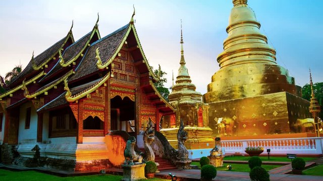 Chiang Mai, Thailand. Illuminated temples of Wat Phra Singh in Chiang Mai, Thailand at sunset. Golden walls and blue sky. Time-lapse at sunset