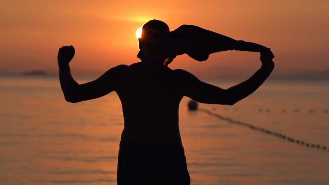 Silhouette of successful man on beach during sunset, super slow motion 240fps
