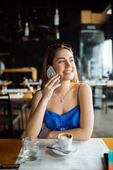 Beautiful woman in cafe using phone