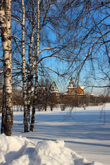 Beautiful terem on the background of birches and glades of snow..
