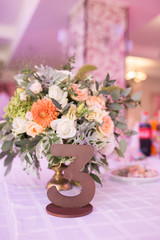 Number three at table for guests on wedding hall. Gold wedding table number.