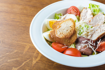 close-up view of gourmet caesar salad on wooden table