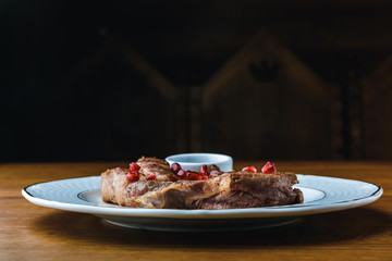 close-up view of delicious grilled steaks with pomegranate seeds on plate