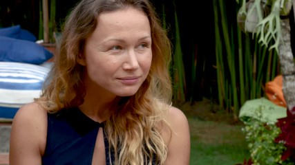 Hipster girl eating pizza and smiling to the camera in the restaurant