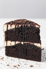 Closeup view of chocolate cake with glaze on white plate