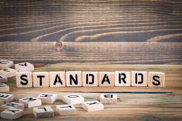 standards. Wooden letters on the office desk, informative and communication background.