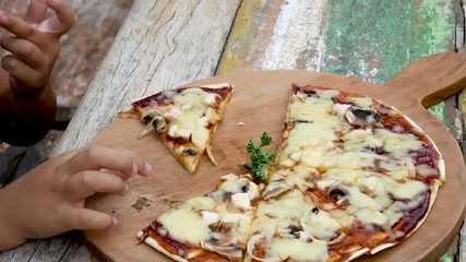 Close up on family taking a pizza slice at park